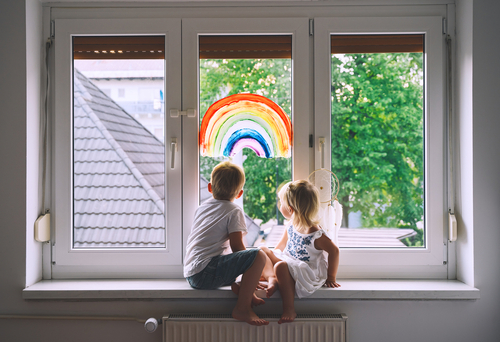 Two children sitting in a window.
