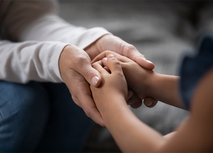 Mother holding child's hands